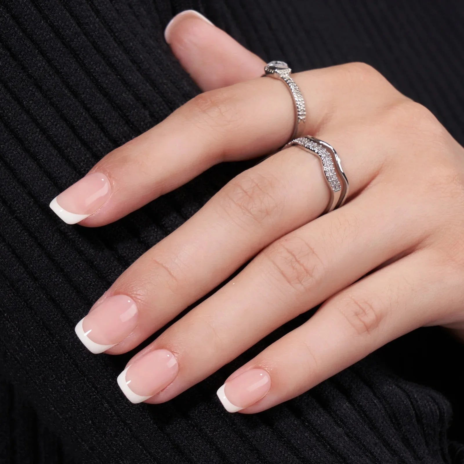 Angelic Aura gelnagels close-up – korte vierkante Franse manicure met twee zilveren ringen