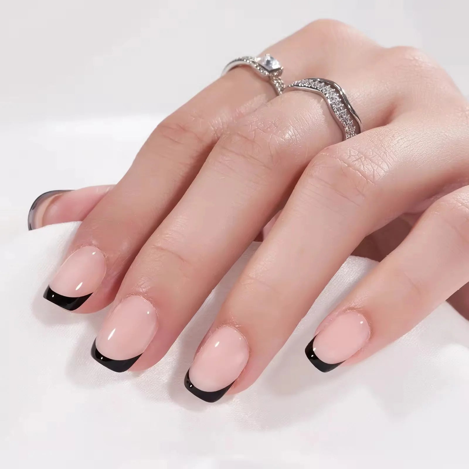 Zwarte Franse vierkante press-on nagels – Sleek Silhouette met zilveren ringen tegen witte achtergrond