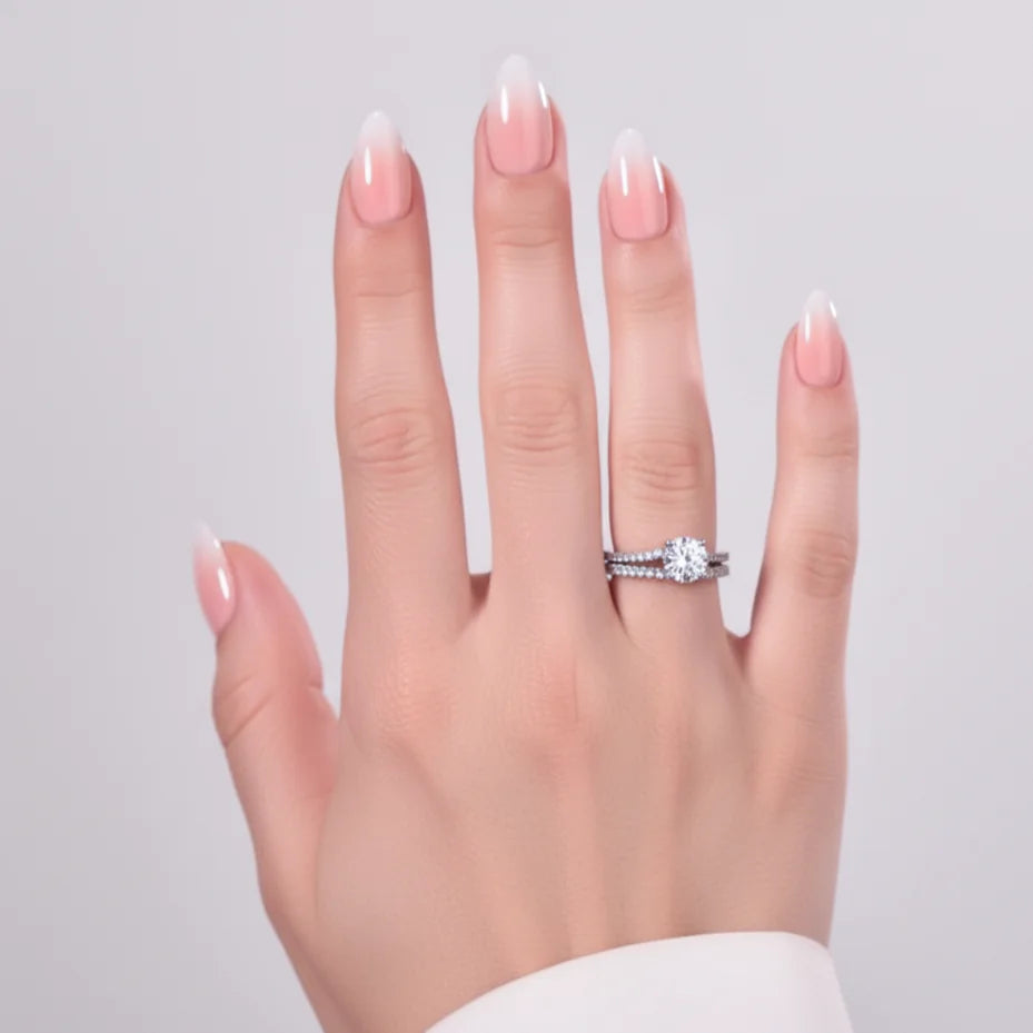 Dreamy Dip amandelvormige press-on nagels – roze-witte ombre met diamantring op modelhand