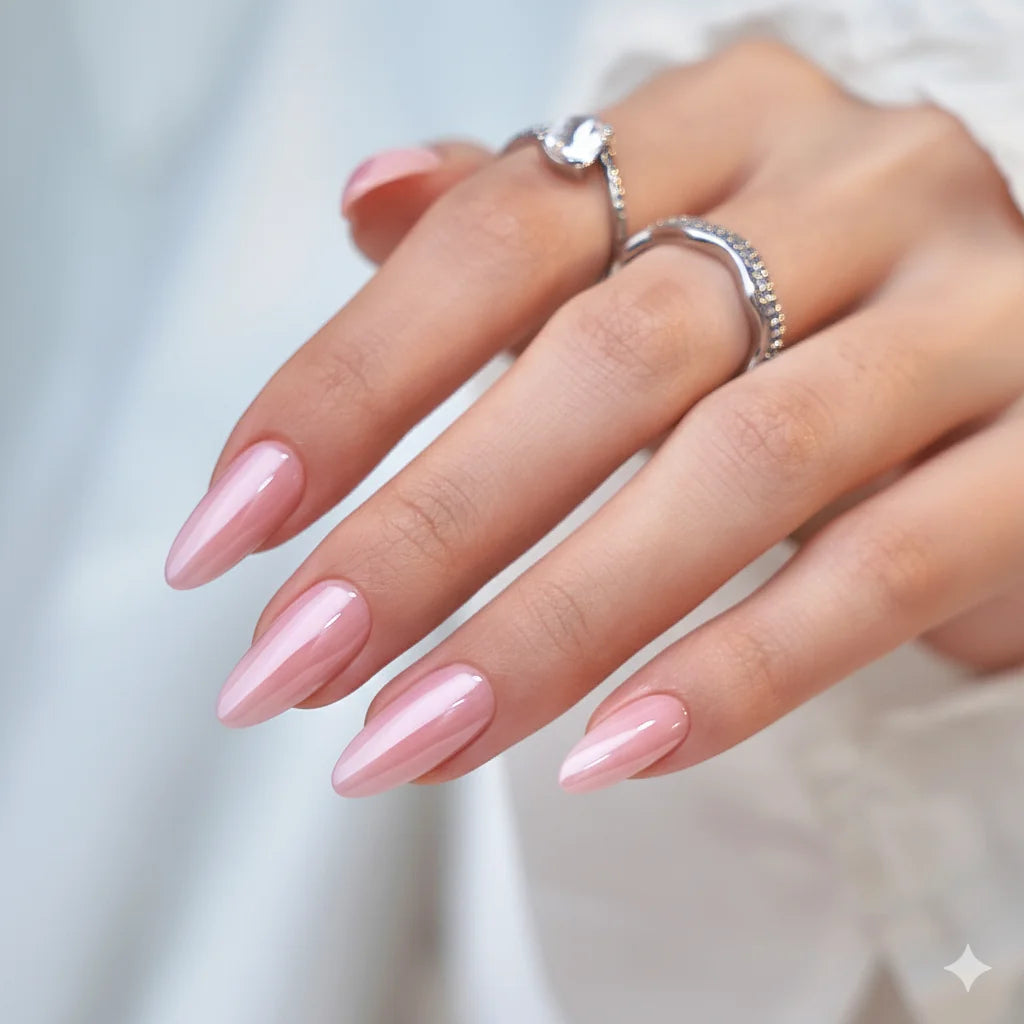 Pinkie Pearl press-on nagels close-up – roze parelglans met zilveren ringen en witte blouse