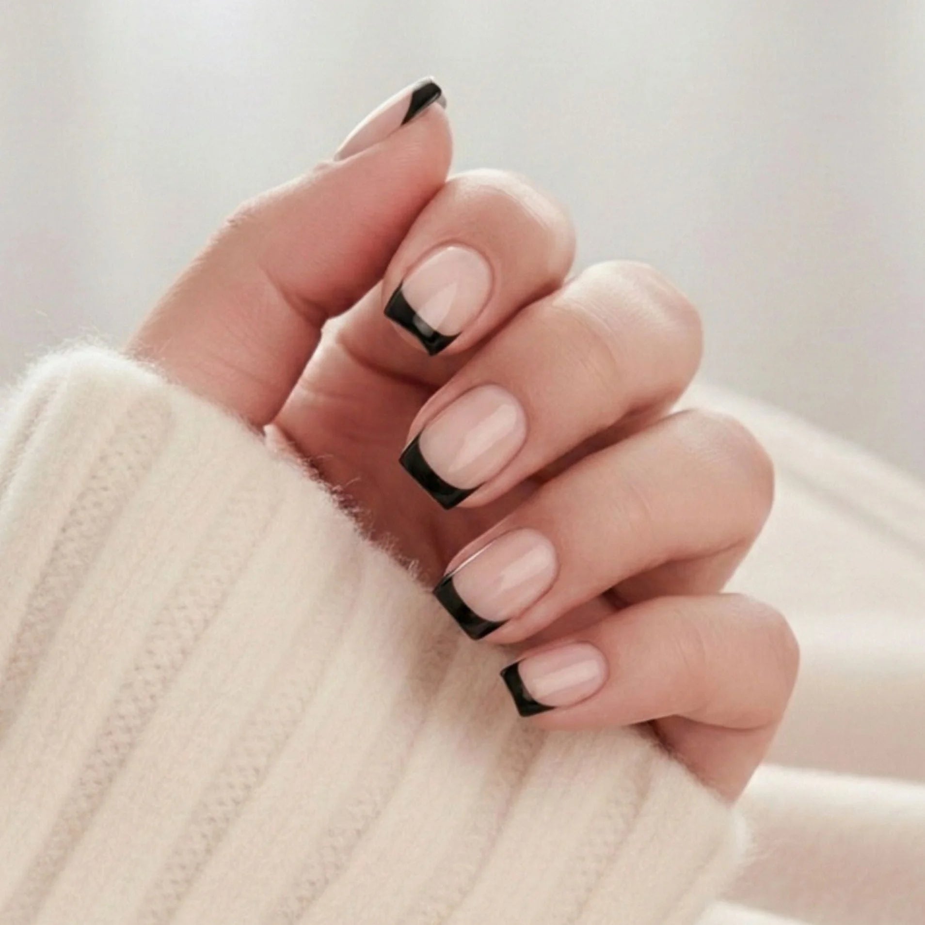 Sleek Silhouette press-on nagels – klassieke Franse manicure in vierkant met zwarte tip tegen crèmewitte gebreide trui