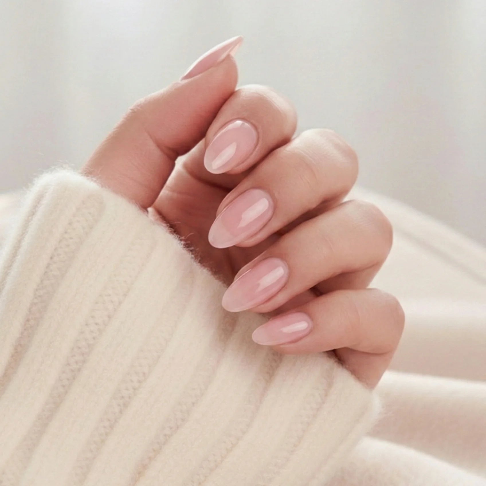 Pinkie Pearl press-on nagels – delicaat roze parel in amandelvorm tegen crème gebreide trui
