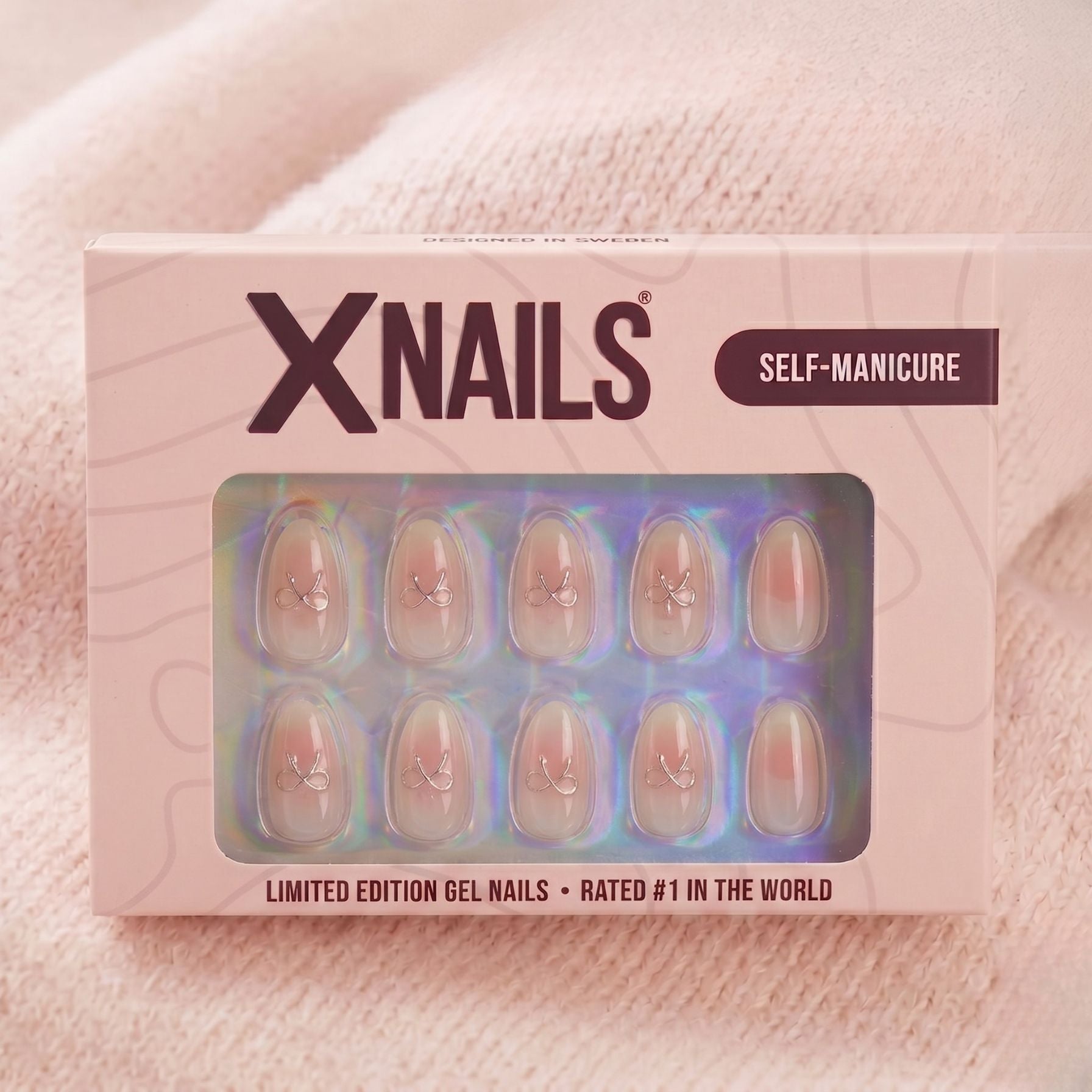 Aura Amoré amandelvormige press-on nagels met wit-roze ombré en zilveren ringetjes, in roze XNails-verpakking voor makkelijke manicure