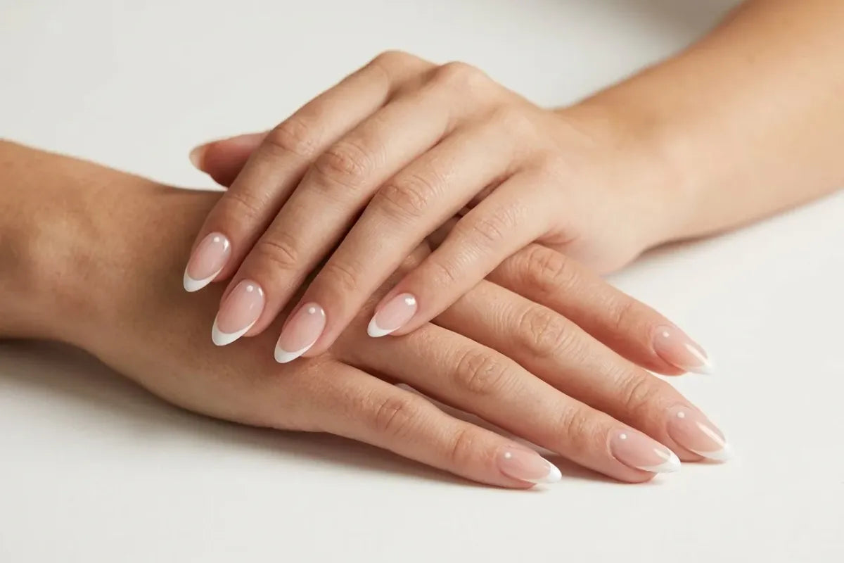 Kunstnagels die lang blijven zitten in french almond op twee verzorgde handen