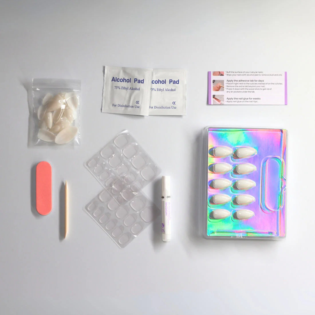 Ruby Romance press-on set met witte amandelvormige nepnagels, lijm, kleefpads, vijl, buffer en instructies voor een makkelijke manicure