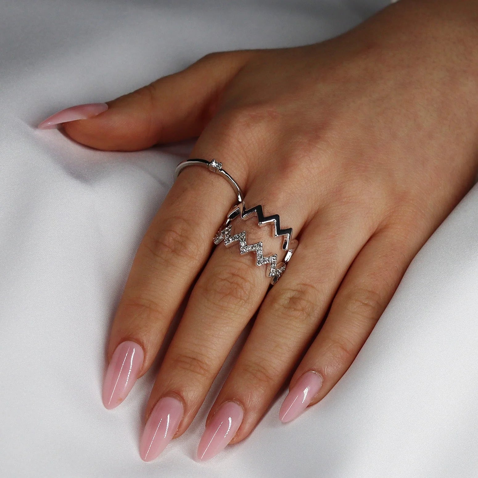 Pinkie Pearl gelnagels styling – roze parelmanicure met zilveren ring tegen wit satijn