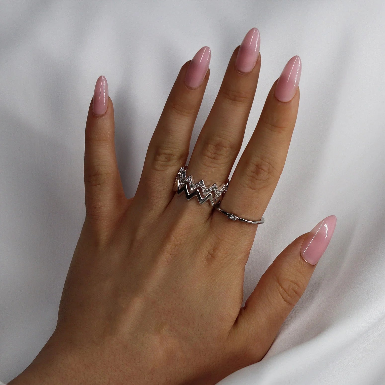 Pinkie Pearl press-on nagels lifestyle – roze parel amandelvorm met opvallende zilveren ring