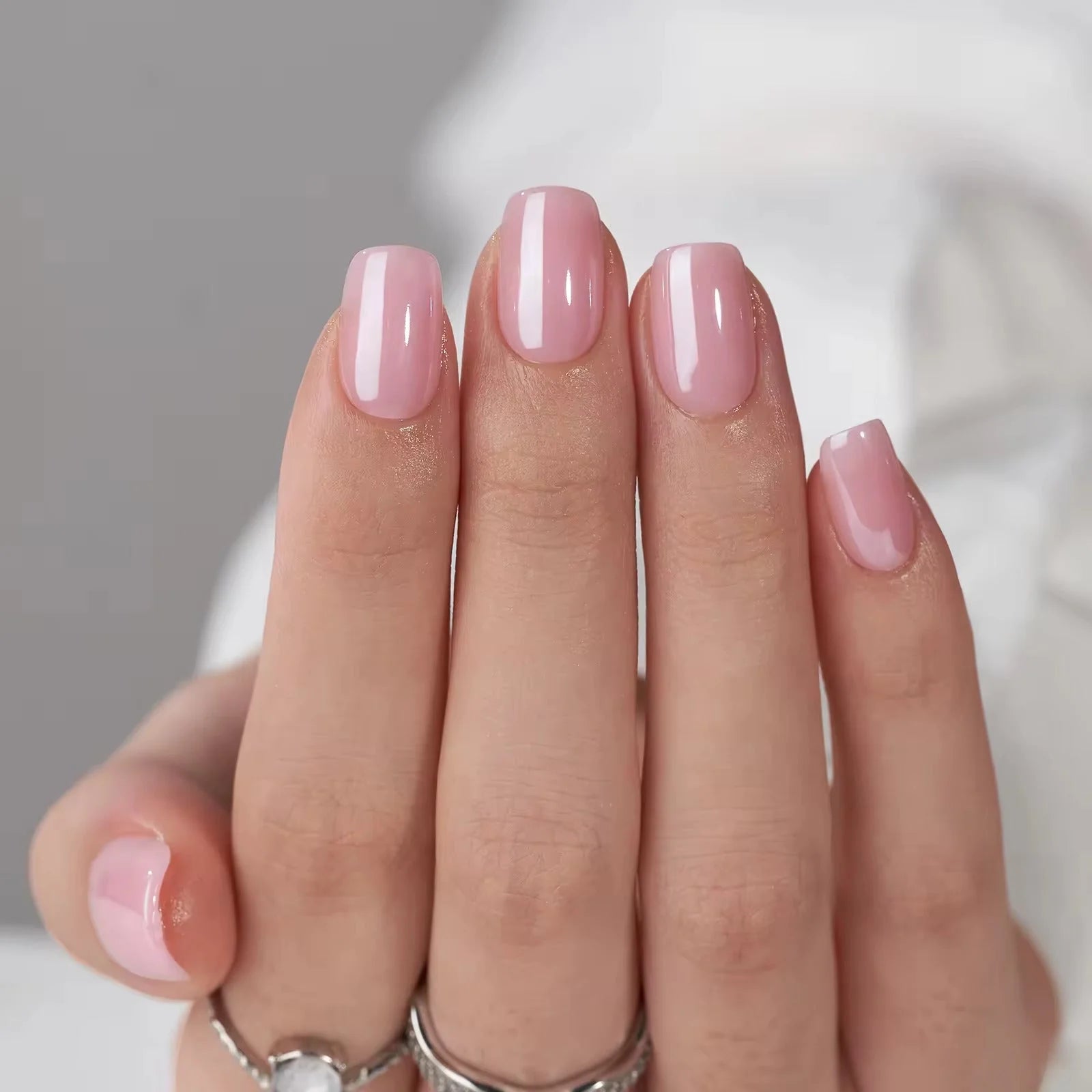 Pinkie Pearl press-on nagels styling – korte square met parelroze glans en zilveren ringen
