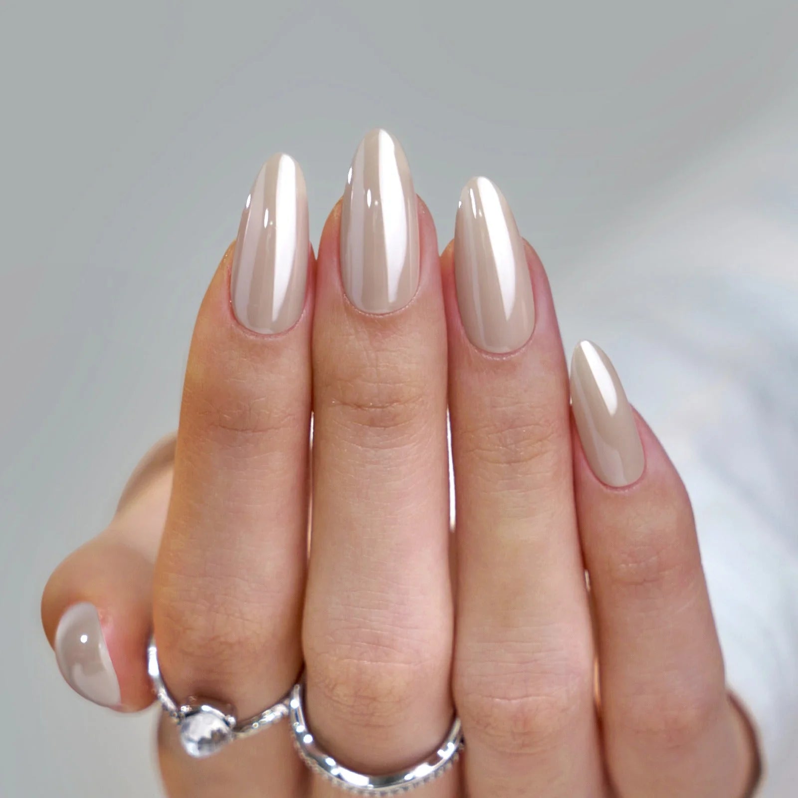 Amandelvormige press-on nagels met parelglans – Pearly Perfection in taupe nude met zilveren ringen
