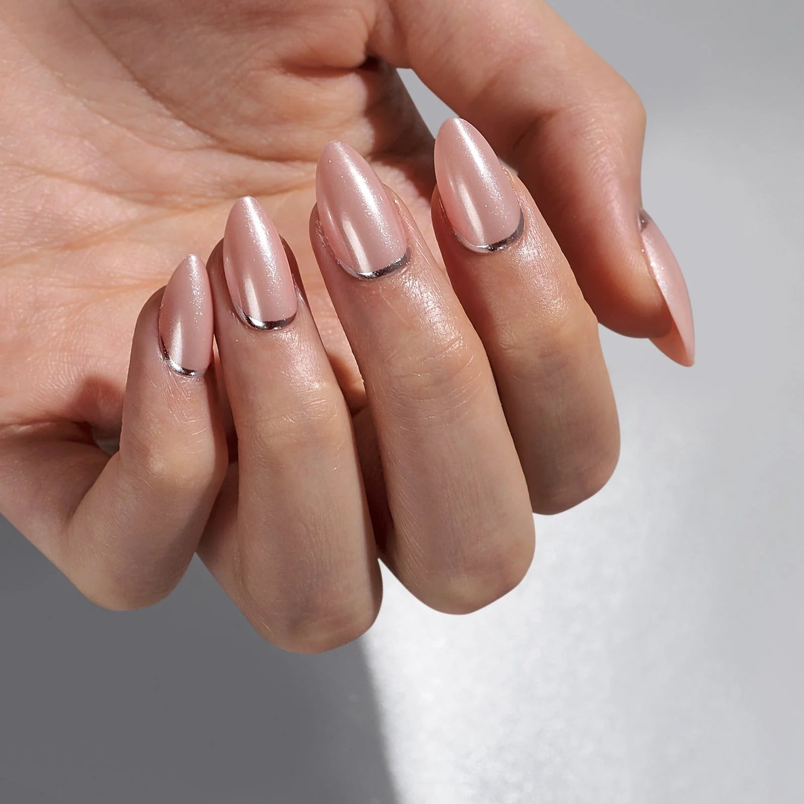 Shimmering Silver gelnagels close-up – pearl nude amandelvorm met chrome zilveren rand