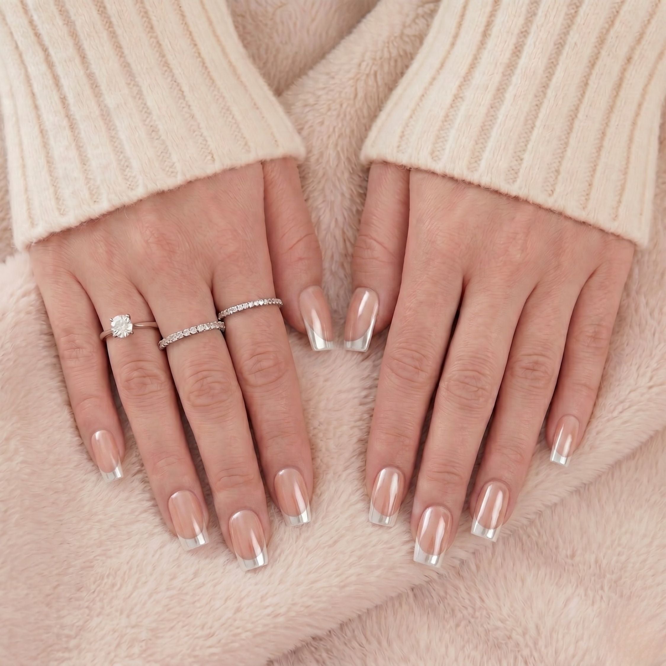 Classic Chrome press-on nagels: korte vierkante manicure met natuurlijke basis en zilveren chrome tips op handen tegen zachte deken