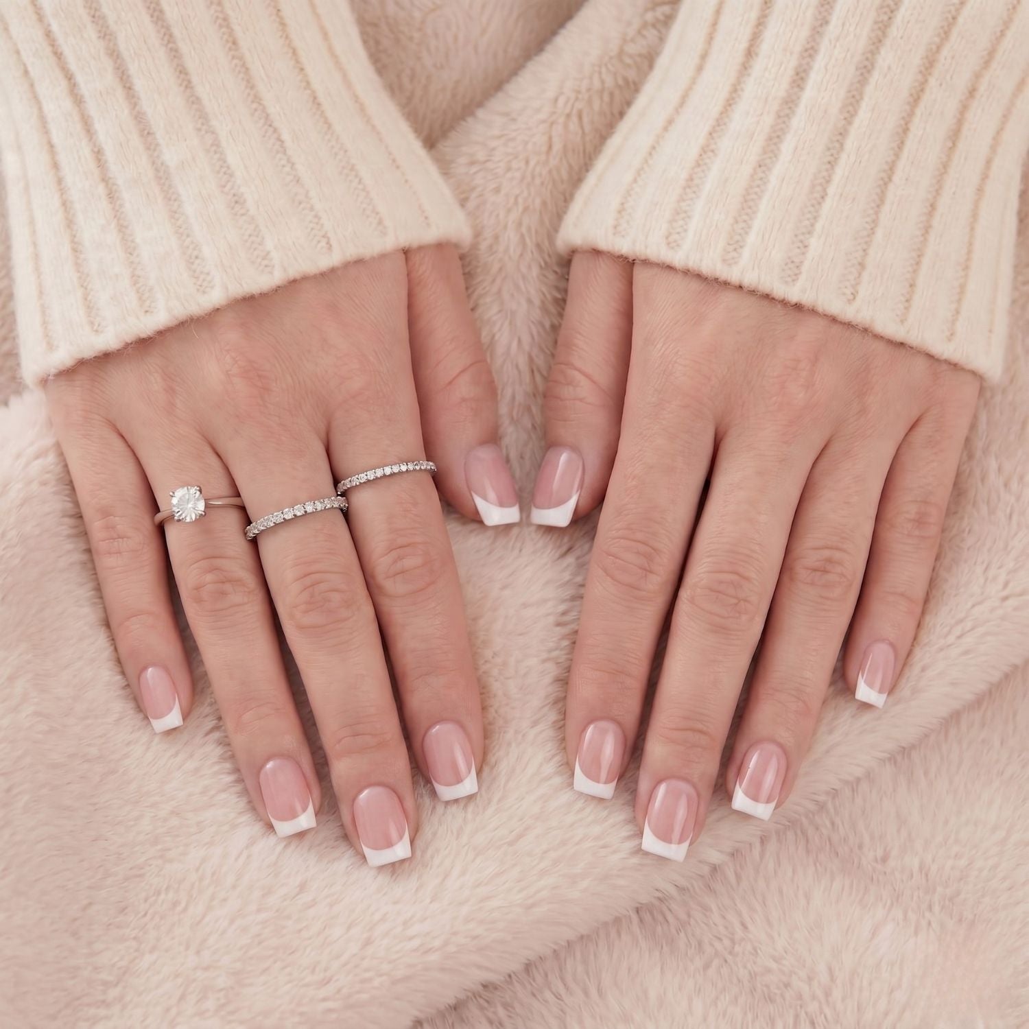Angelic Aura press-on nepnagels: korte Franse manicure met witte tip. Natuurlijke basis, vierkante vorm. Handen op deken