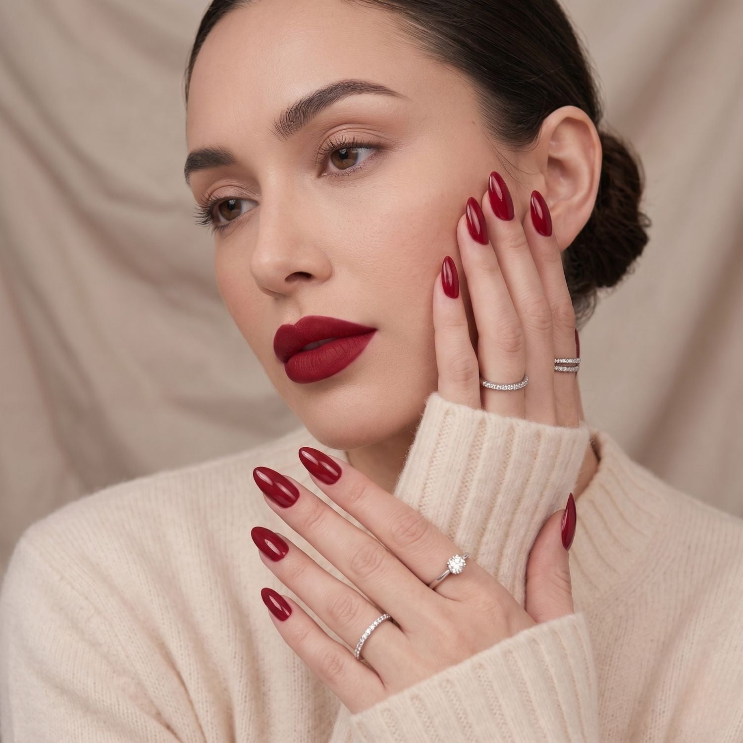 Ruby Romance press-on nagels. Model met glanzende donkerrode amandelvormige nepnagels, een verfijnde manicure