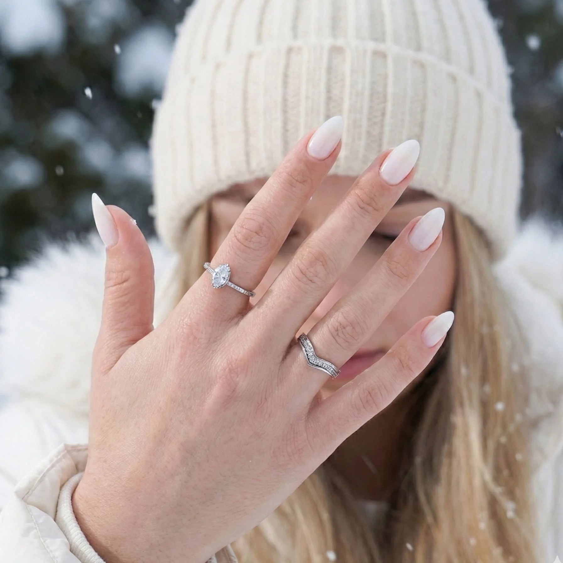 Satin Snow press-on nagels in winterse omgeving – amandelnagels tegen witte gebreide muts