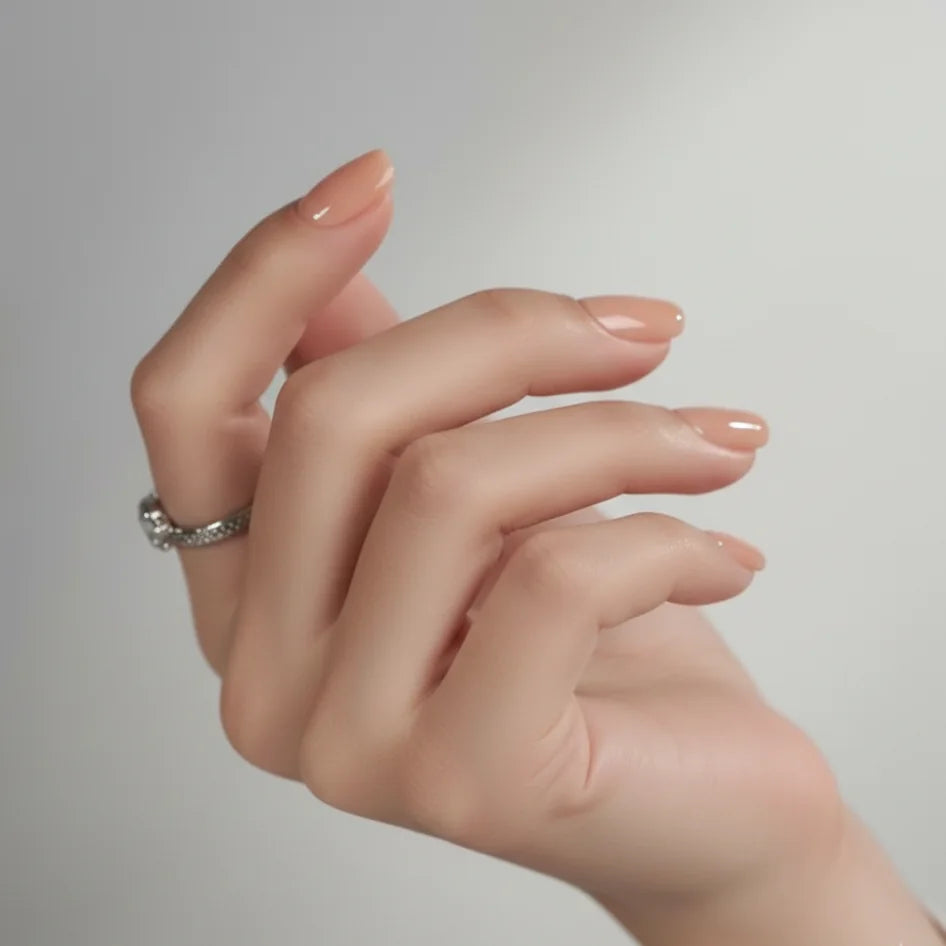 Korte vierkante kunstnagels – Honey Heaven nude met subtiele glans tegen grijze achtergrond