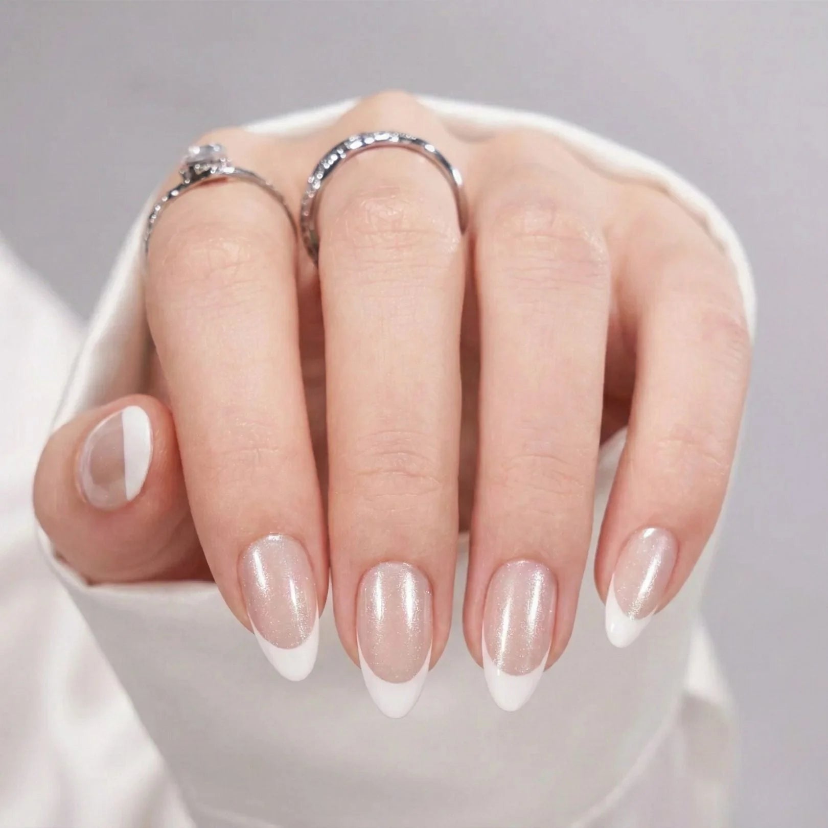 Sweet Sprinkle nagels op hand – amandelvormige nepnagels met shimmer nude basis en witte Franse tip