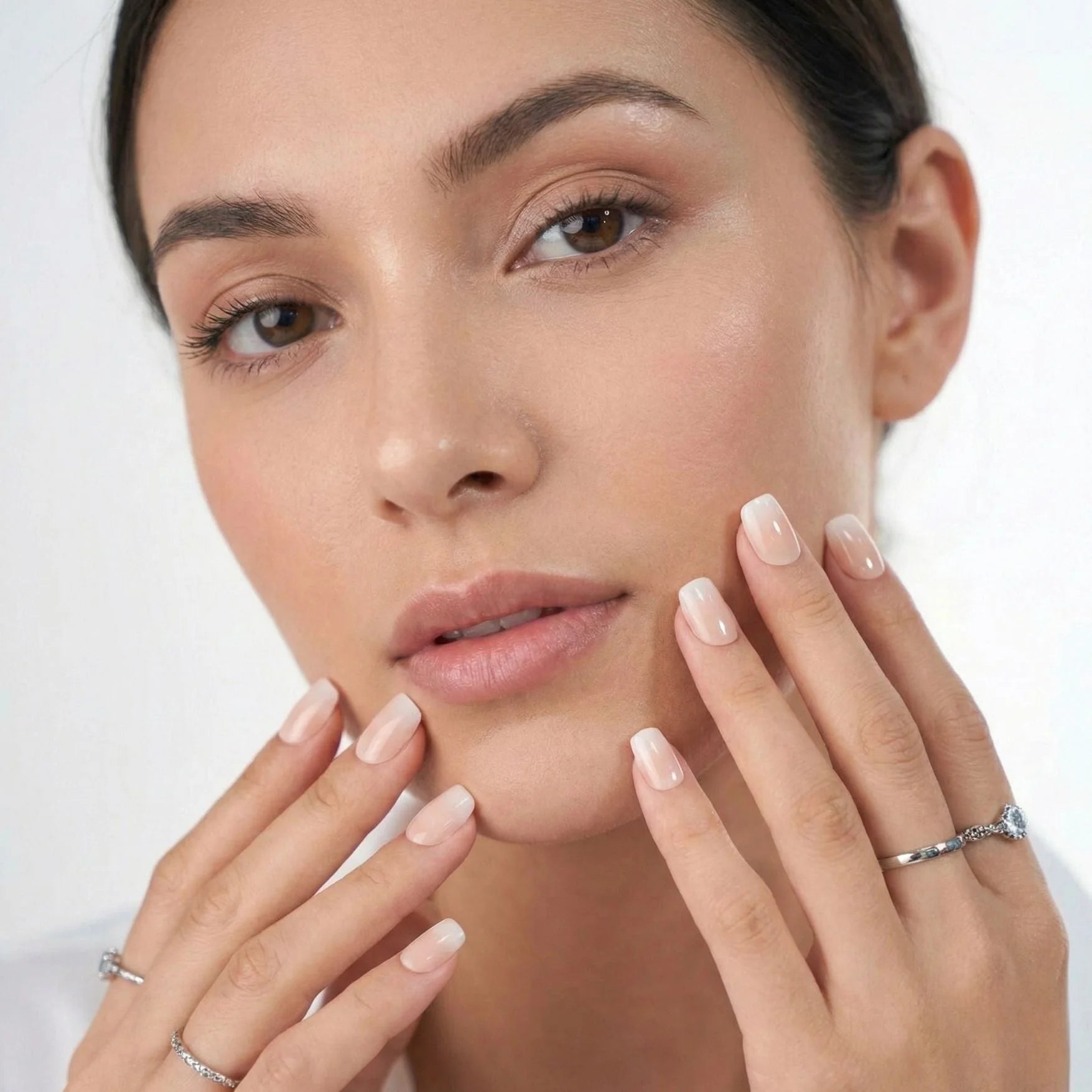 Dreamy Dip press-on nagels close-up – model houdt handen bij gezicht met nude vierkante ombré