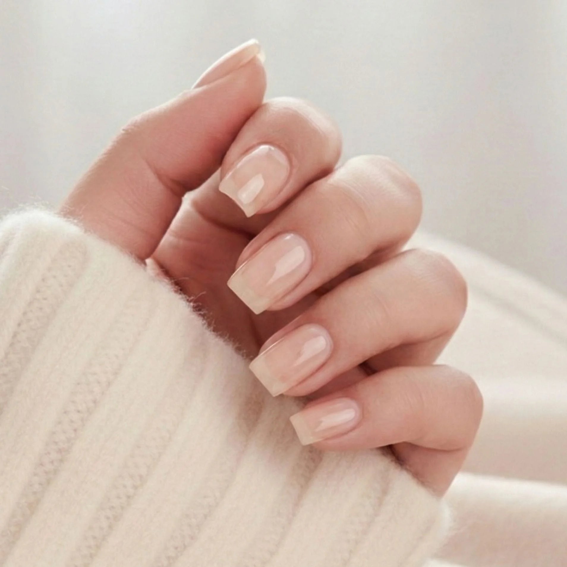 Heavenly Halo press-on nails – korte vierkante kunstnagels in zacht nude met subtiele schimmer tegen beige trui