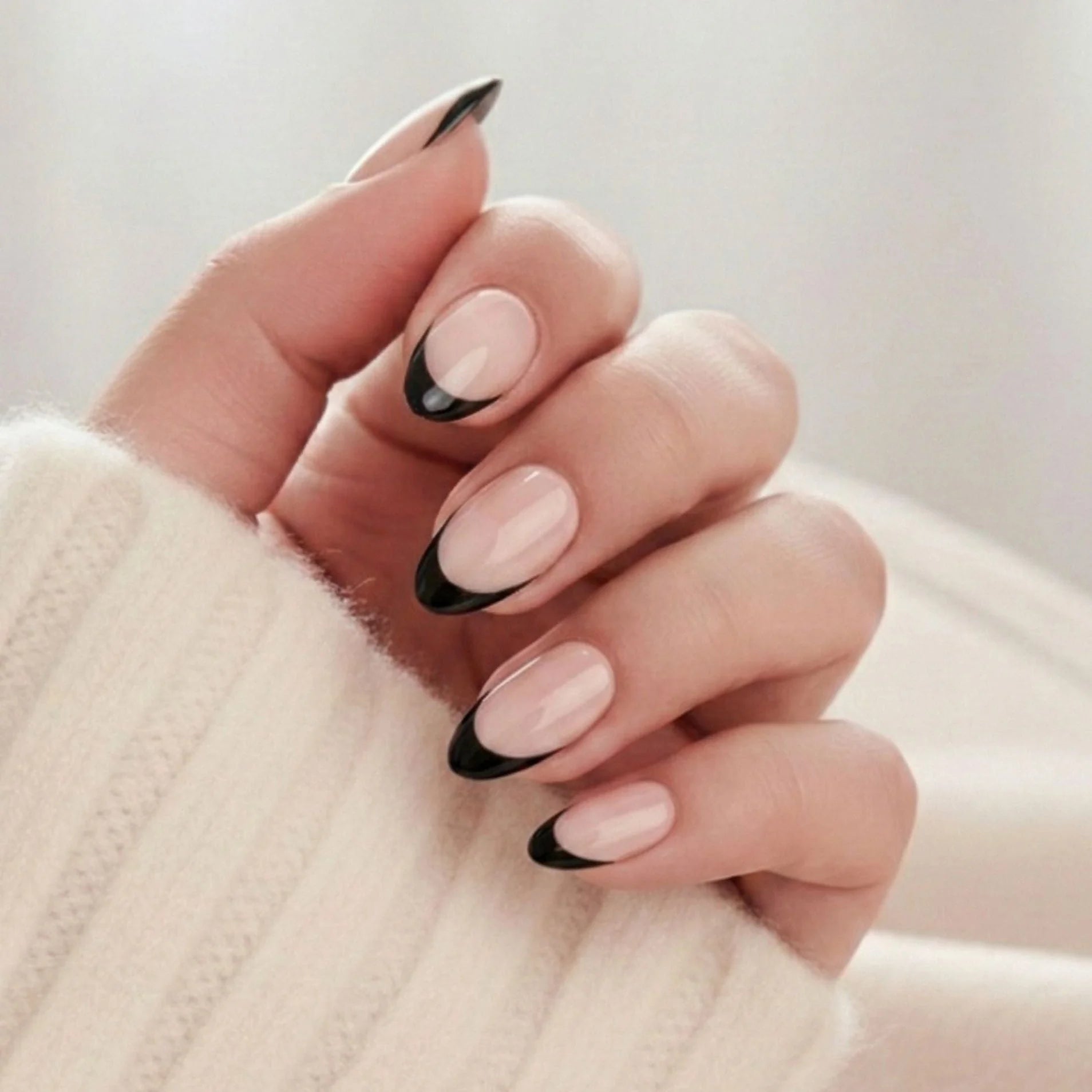Sleek Silhouette press-on nagels – amandelvormige plaknagels met zwarte Franse tip tegen zachte beige trui