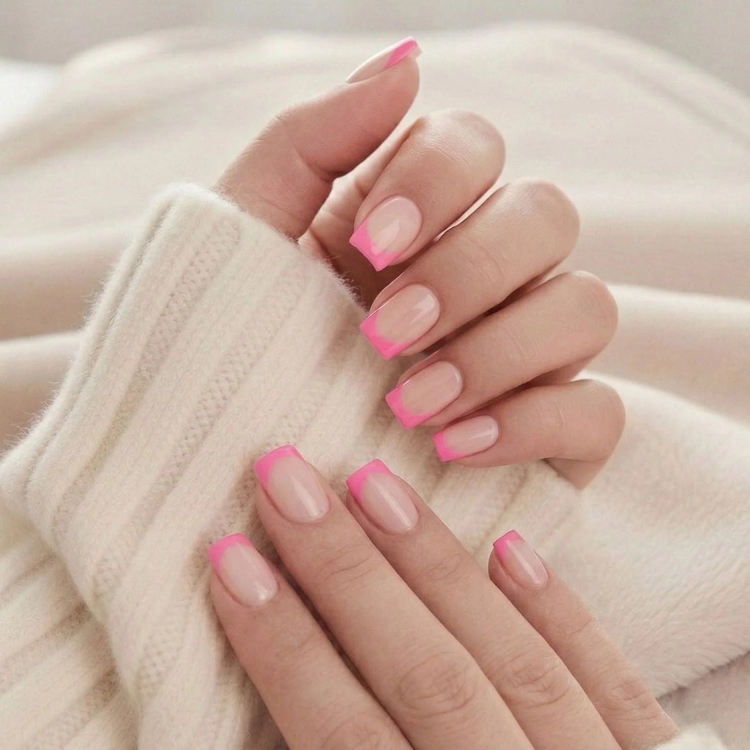 Pixie Pink nagels op hand – roze franse tip korte square tegen beige gebreide trui