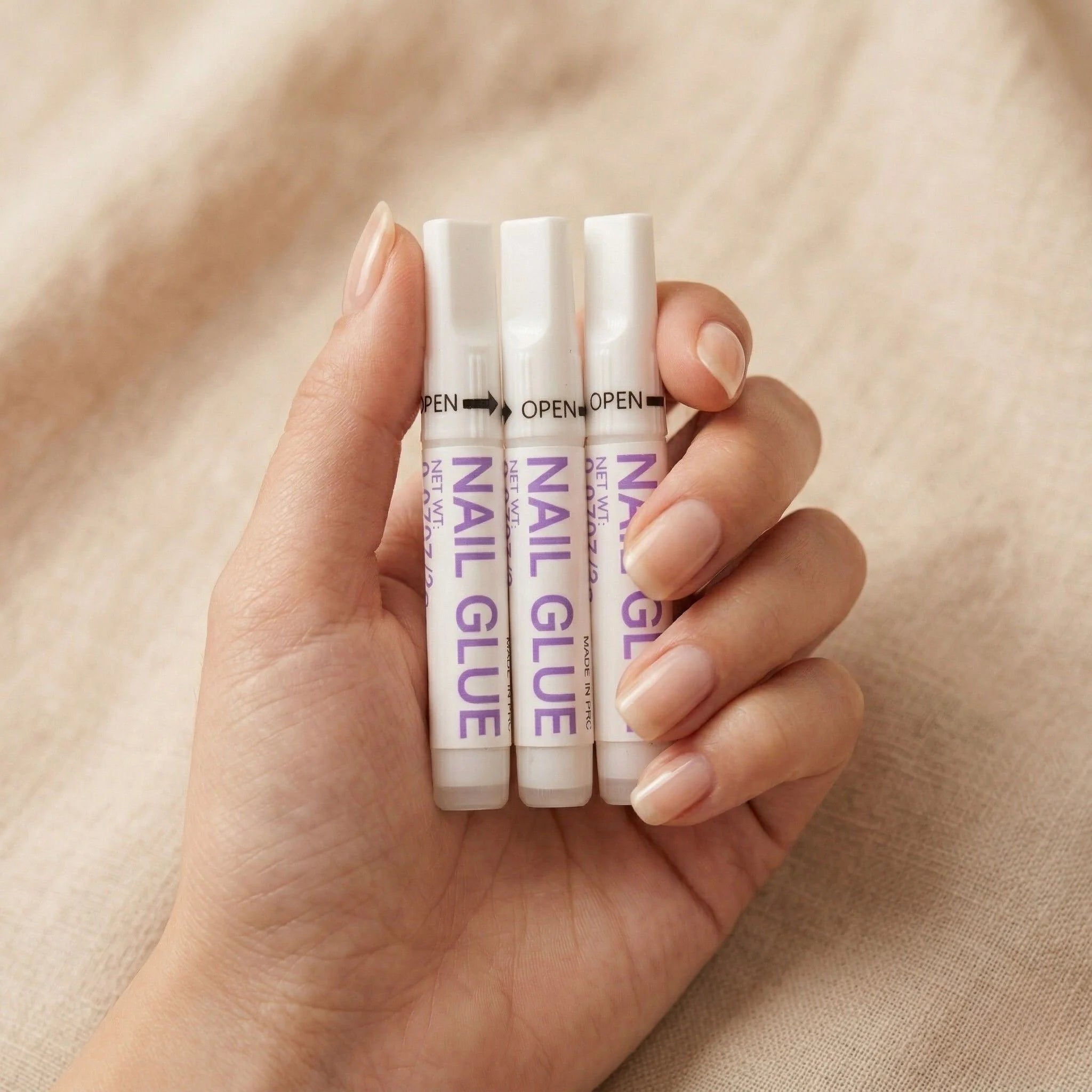 XGlue nagellijm 3-pack in hand – sterke lijm voor press-on nagels met precisietuit