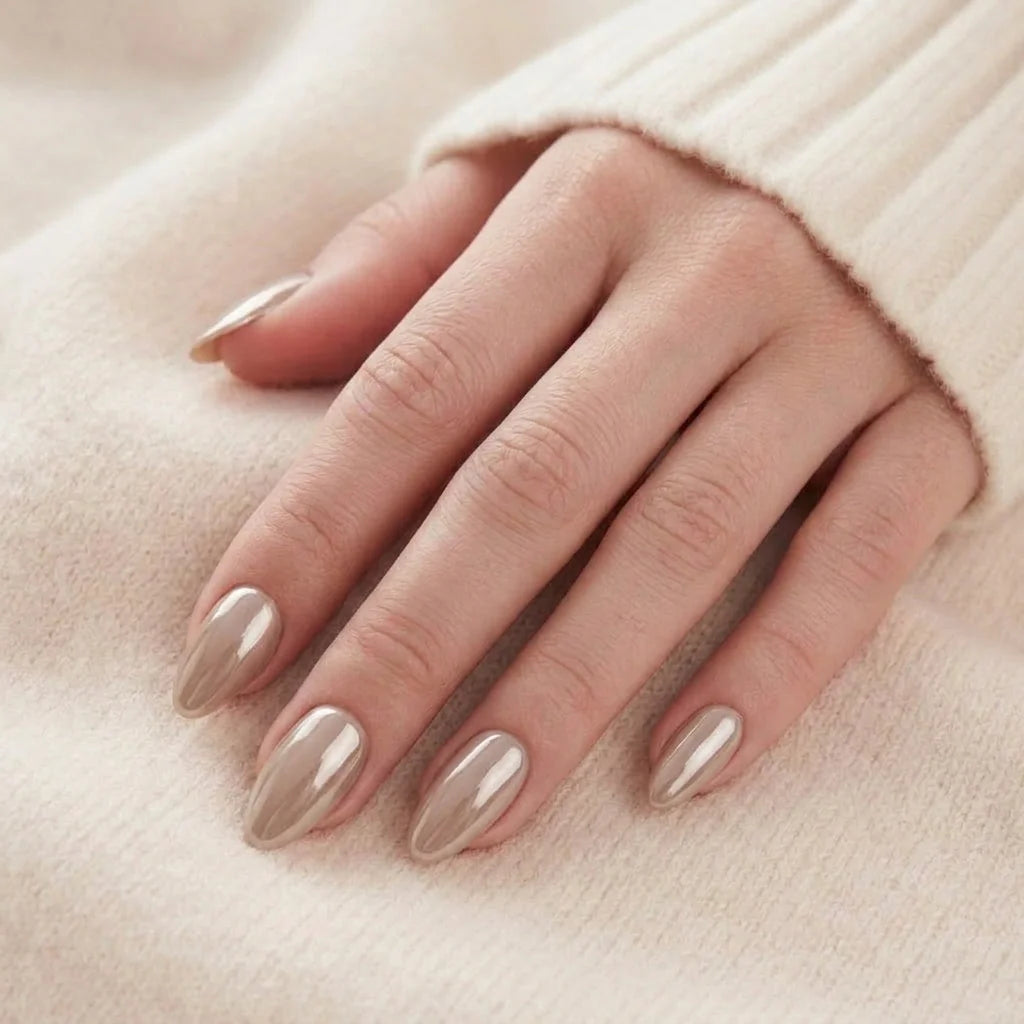 Pearly Perfection nagels op de hand – amandelvormige gelnagels in parelmoer taupe rusten tegen beige trui
